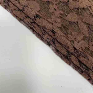 Close-up of intricate floral lace texture and coffee brown sheer mesh fabric detail