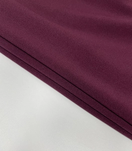 Dettaglio ravvicinato del tessuto a maglia viola scuro con fibre e drappeggio