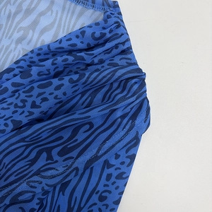 Detail of royal blue mesh fabric featuring black zebra and leopard prints with gathers