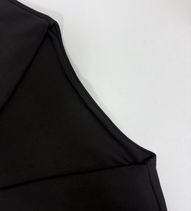 Detailed close-up of fine flat-lock stitching on a black long sleeve mini dress