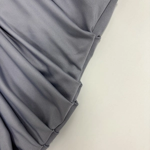 Detailed macro view of the ruched grey-purple knitted elastic fabric of the dress
