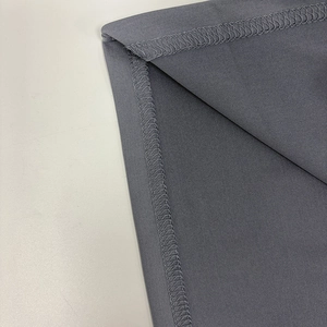 Detail of flatlock stitching and fine knitted texture on a gray bodycon dress hem