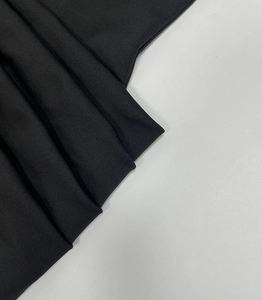 Vista dettagliata della fine trama a maglia e del drappeggio del tessuto elastico nero