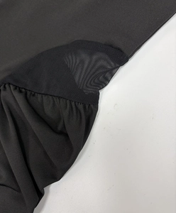 Close-up of black dress with sexy mesh panels and detailed stitching on elastic fabric