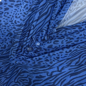 Detail of electric blue leopard mesh fabric with fabric-covered buttons and V-pleat design