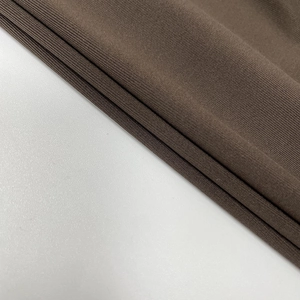 Vista macro dettagliata del tessuto a maglia a coste marrone scuro di questo abito