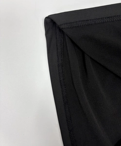 Close-up detail of smooth double-stitch sewing and high-elasticity black knitted fabric