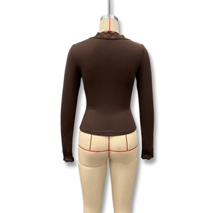 Détail du haut en maille marron foncé avec dentelle délicate sur la vue de derrière