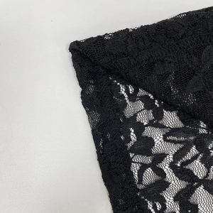 Close-up of the intricate floral lace detail and sheer mesh on the black split hem dress