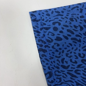Close-up of blue mesh fabric featuring black leopard print and detailed overlock stitching