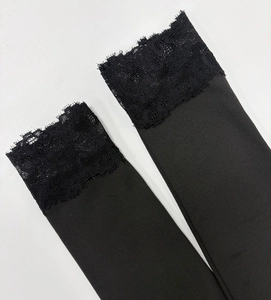 Détail du tissu en maille noire extensible et de la bordure en dentelle florale délicate