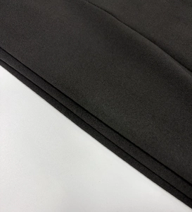 Gros plan sur la texture du tricot noir de ce haut à manches longues et col en V