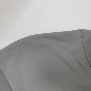 Dettaglio della cucitura della spalla e del tessuto jersey grigio dell'abito a maniche lunghe