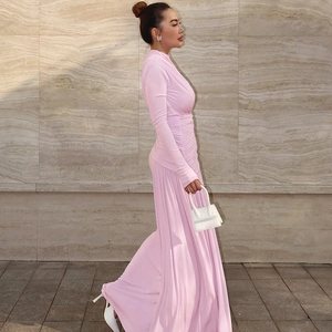 Close-up of pleated texture and elegant draping on pink long sleeve maxi dress