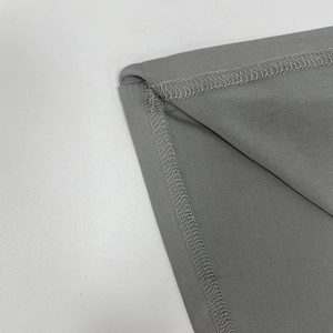 Dettaglio ravvicinato della cucitura overlock professionale sull'orlo grigio