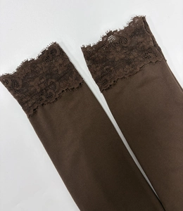 Gros plan de poignets marron avec dentelle élégante et texture en coton élastique