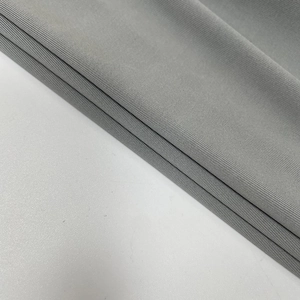 Dettaglio macro della trama in maglia a coste grigia di questo abito da sera alla moda