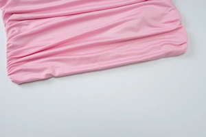Close-up detail of pink pleated chiffon fabric with fine elastic horizontal texture