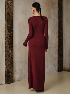 Back view of a slim fit wine red long sleeve dress showing elegant floor-length draping