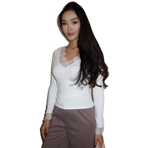 Haut moulant blanc à col en V et manches longues avec dentelle délicate pour look féminin