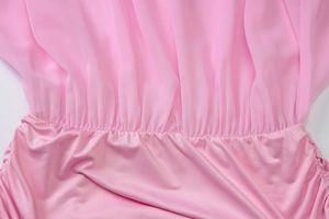 Detail of pink chiffon dress showing ruched waist stitching and pleated texture