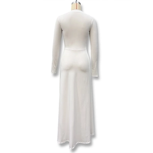 Détail de robe longue blanche à manches longues montrant la coupe ajustée et le drapé
