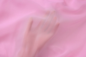 Detail shot of sheer pink mesh fabric texture showing lightweight transparency on skin