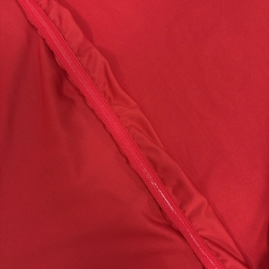 Détail du tissu rouge de la robe avec couture plate et fermeture éclair invisible