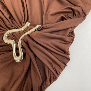 Detail of brown ruched dress with decorative gold metal hardware buckle on waist