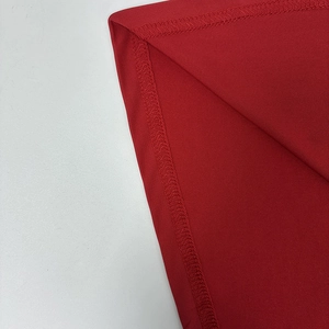 Vue macro détaillée des coutures overlock et du tissu en maille rouge sur une robe
