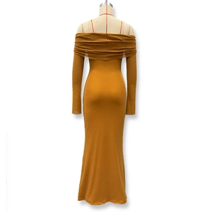 Detail of ginger yellow glitter fabric and off-shoulder back cut on long dress