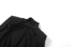Detailed macro view of the ruched turtleneck and silky knitted fabric of the black dress