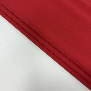 Gros plan sur le tissu en maille rouge foncé avec des textures horizontales et douces