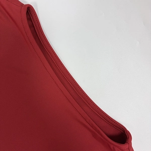 Détail de la couture à double aiguille et du tissu en maille fine sur la robe rouge