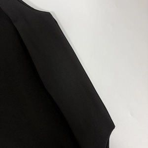 Vue détaillée montrant les coutures précises et la texture de la robe en tissu noir