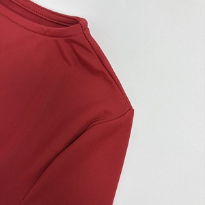 Détail de robe bordeaux à col rond avec texture côtelée verticale et coutures soignées