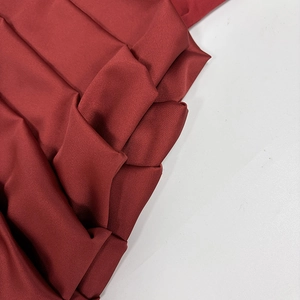 Gros plan sur un tissu satiné bordeaux avec une texture plissée élégante et soyeuse