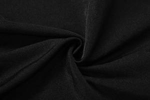 Close-up of black textile fabric with fine twill texture and soft draped pleats detail