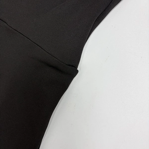 Détail de la maille noire montrant les coutures précises et la texture du tissu