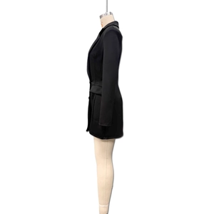 Detail of black long-sleeve blazer dress featuring side view with structured waist pockets