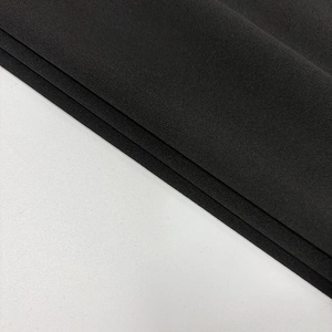 Vue macro détaillée de la texture du tissu en maille noire montrant la qualité du tissage