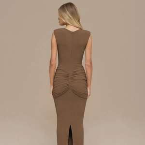 Close-up of the elegant ruched side detailing and high slit on a brown sleeveless dress