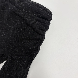 Close-up of black ruched fabric with silver glitter shimmer and textured pleats