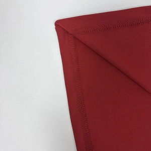 Gros plan détaillé montrant les coutures surjetées sur le tissu en maille rouge de qualité
