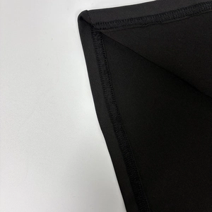 Vue macro détaillée montrant les coutures surjeteuses professionnelles d'une robe en tricot