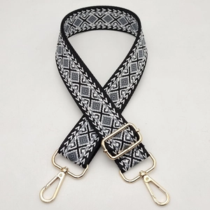 Detail of geometric diamond pattern shoulder strap with gold metal swivel hooks