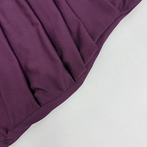 Detail of plum purple knit dress featuring fine vertical ribbed texture and elegant draping