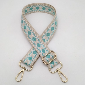Detail of teal and beige geometric diamond woven strap with gold lobster clasps
