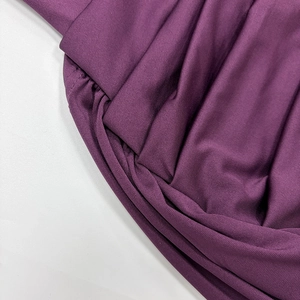 Macro shot of elegant deep purple knitted dress featuring intricate pleated texture details