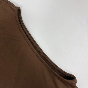 Détail gros plan de la robe marron foncé montrant la couture double aiguille et le tissu